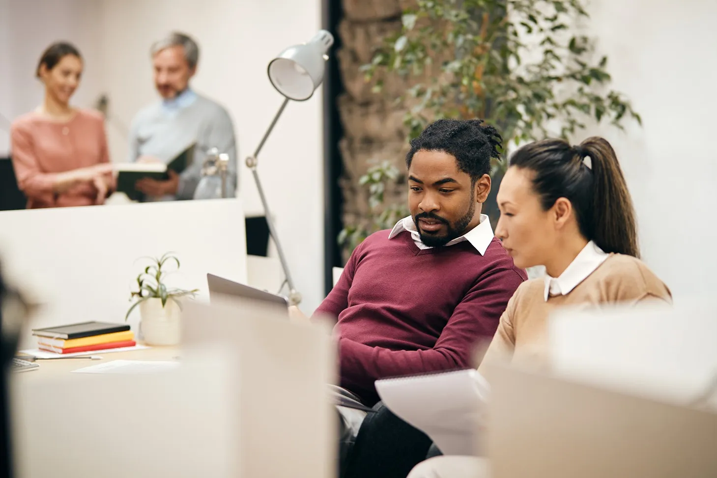 Man and woman in an office space working together on a computer