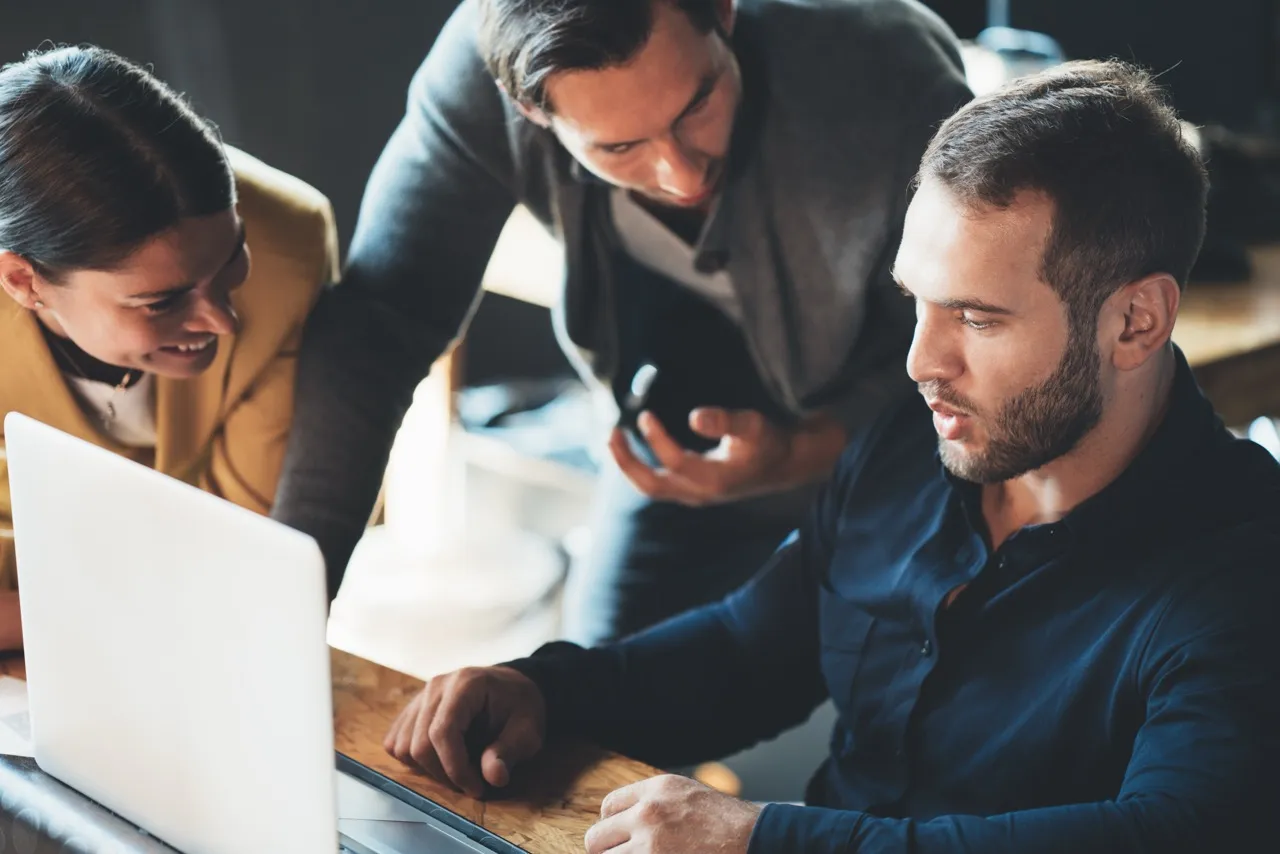 group making conversation around computer