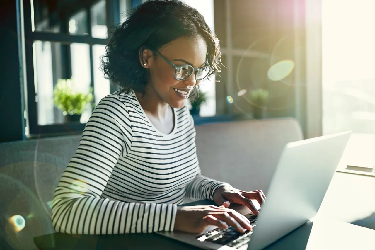 woman focused and smiling looking at her computer