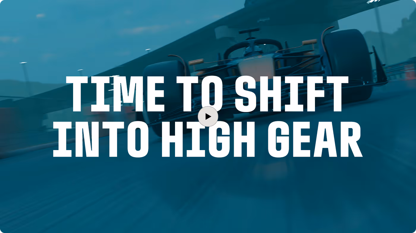 Rear view of a red race car on a wet track with text overlay saying 'Time to shift into high gear' and a play button in the center.