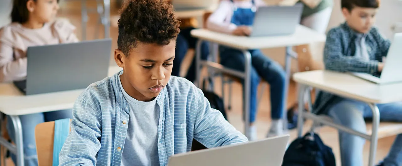 students using laptops in a classroom