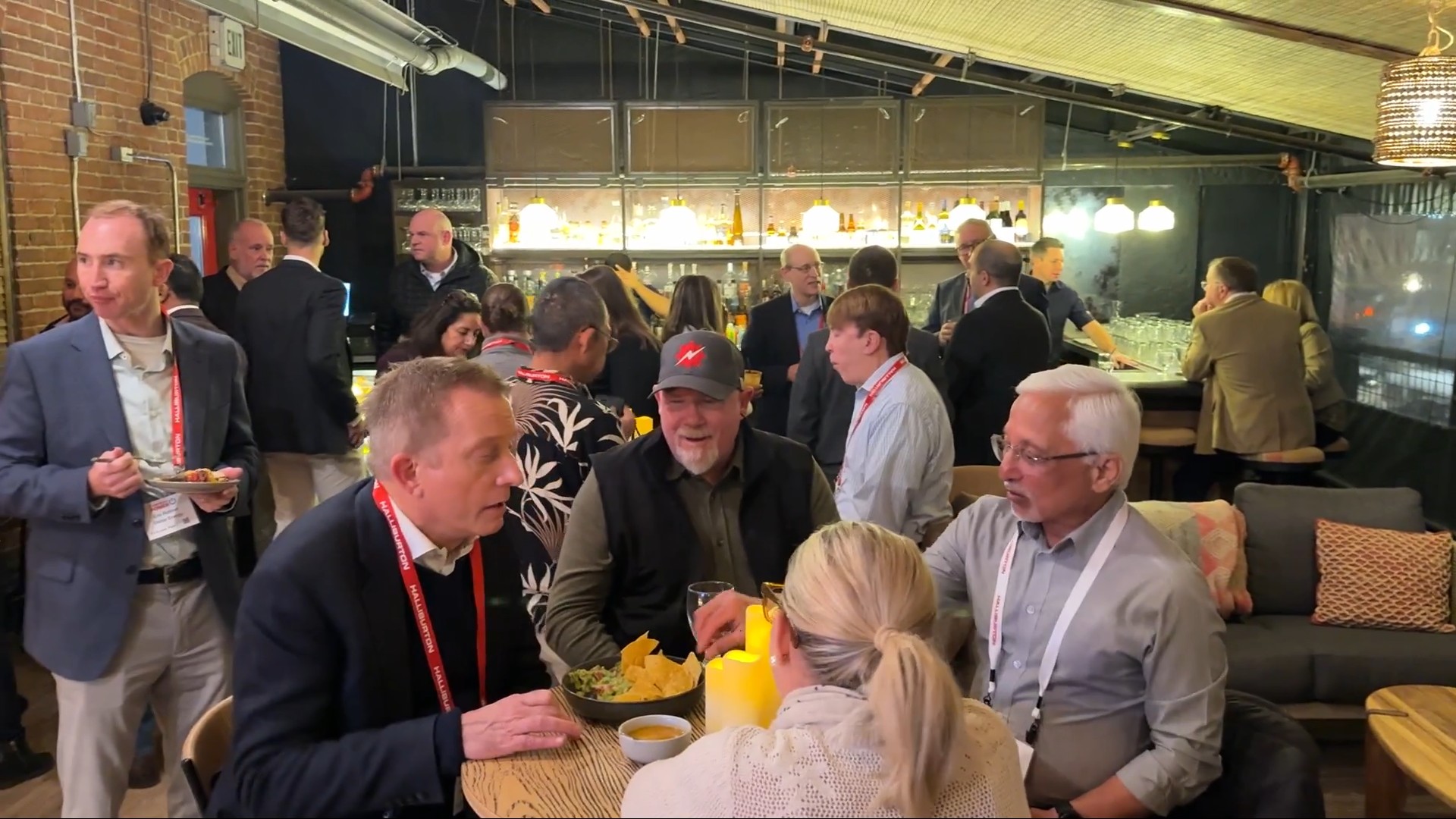 guest enjoying conversation over food & drink at The Planet Group's after hours event at Tamayo