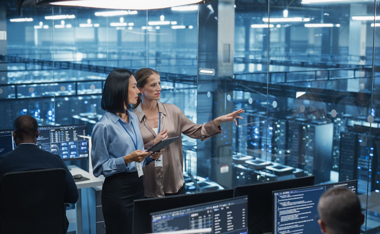 In a Modern Data Center, Data Scientist and AI Specialist Analyze Algorithms on a Tablet Computer