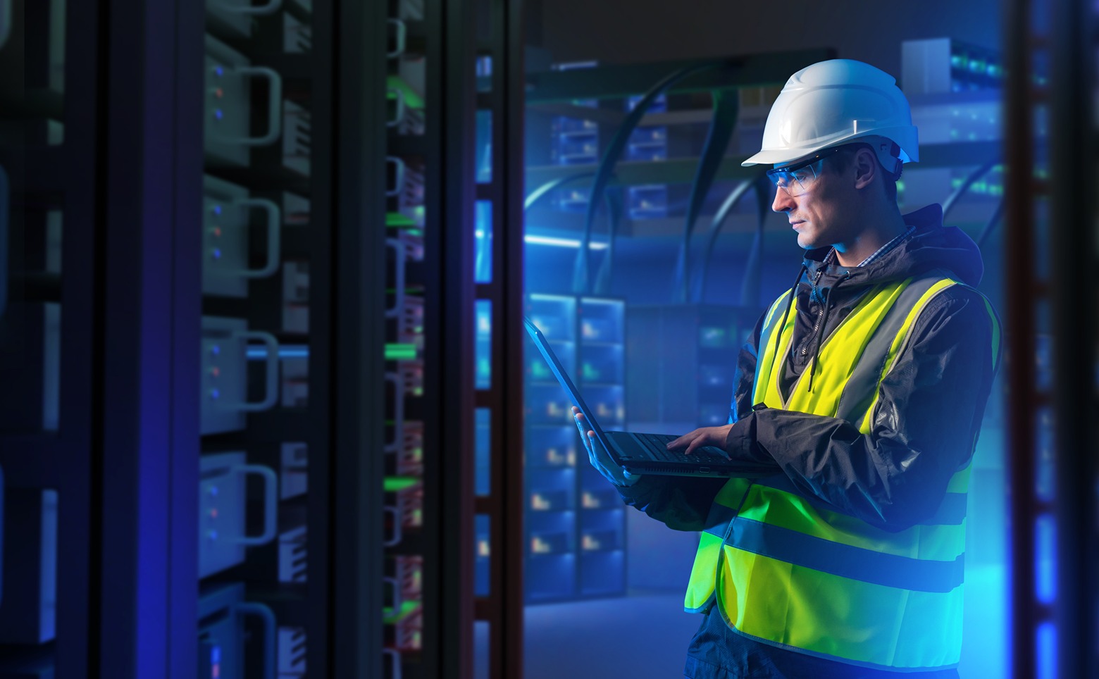 System administrator with computer. Server racks emit neon light.
