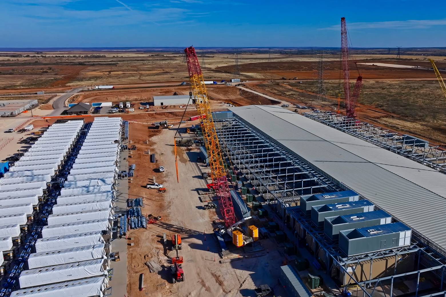 Aerial view of data center construction with BESS batteries and red cranes