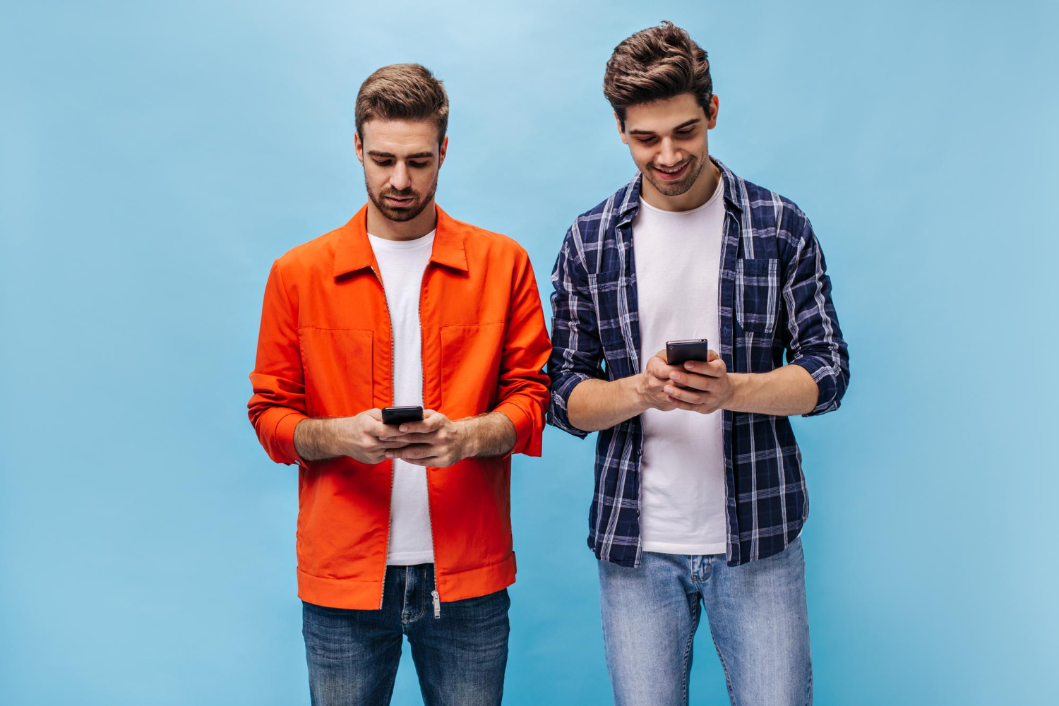 To menn som bruker mobiltelefonen med blå bakgrunn.