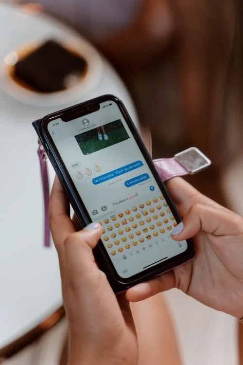 Person skriver en melding på en mobiltelefon.