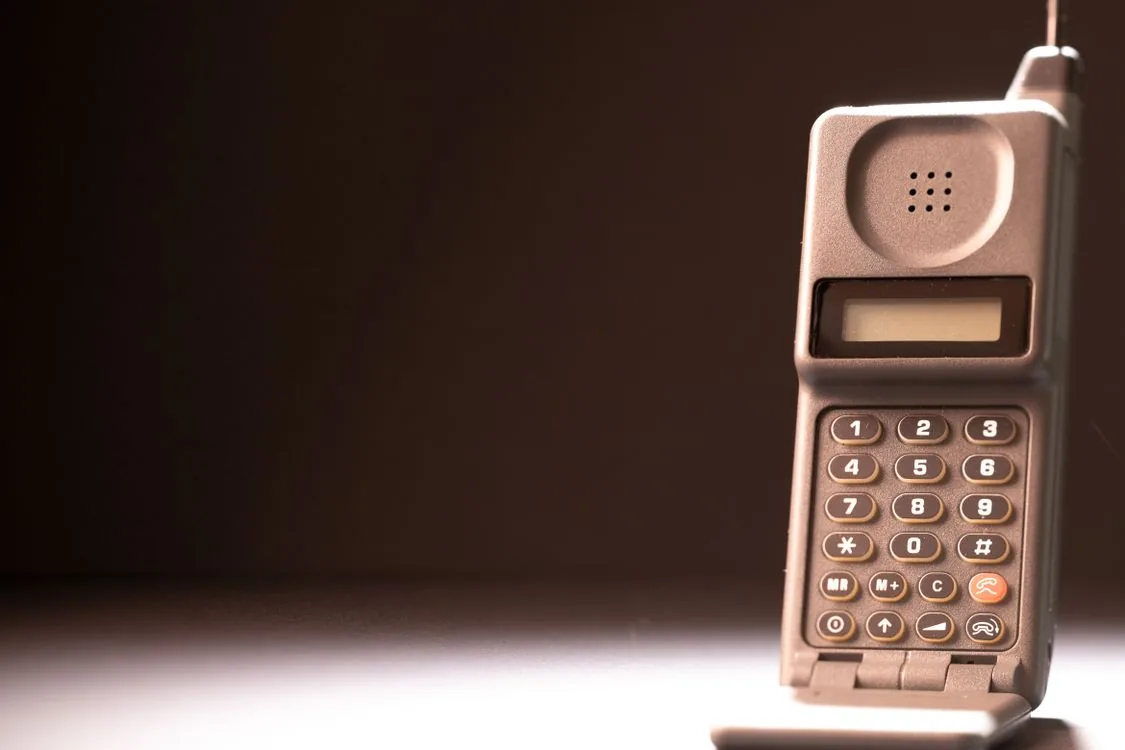 Eldre mobiltelefon med tastatur og antenne.