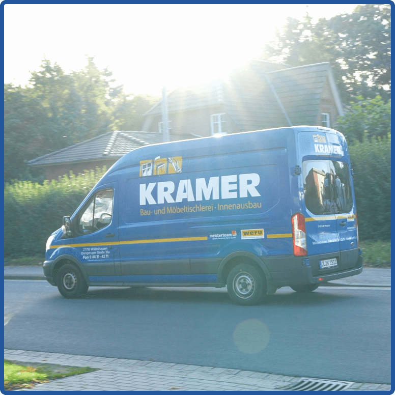 Ein Sprinter der Tischlerei Kramer in Seitenansicht, auf der Straße vorbeifahrend, Sonne im Hintergrund