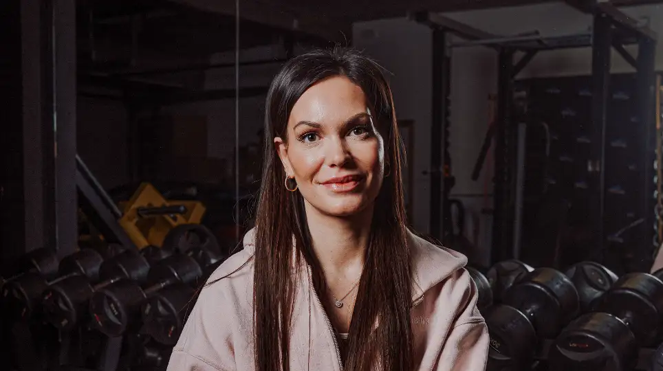 jonge vrouw met zwart haar die poseert in een fitness