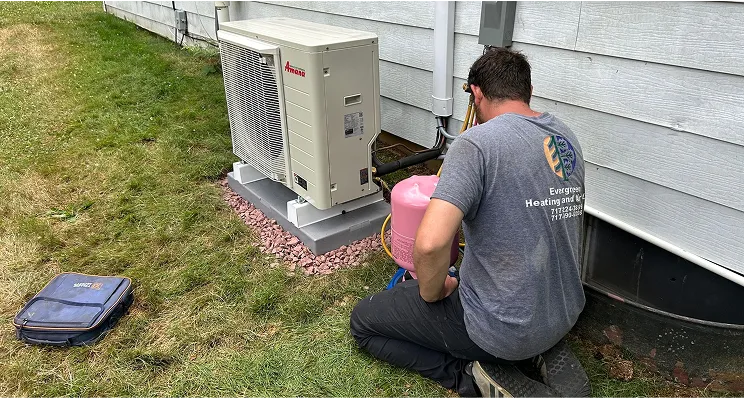 Technician servicing outdoor heat pump