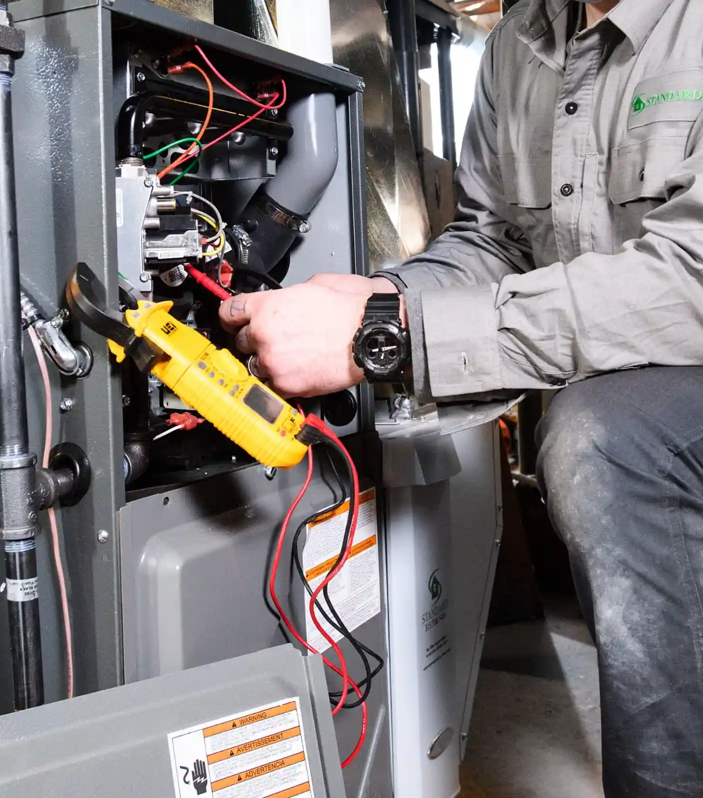 Technician tests furnace with a multimeter.