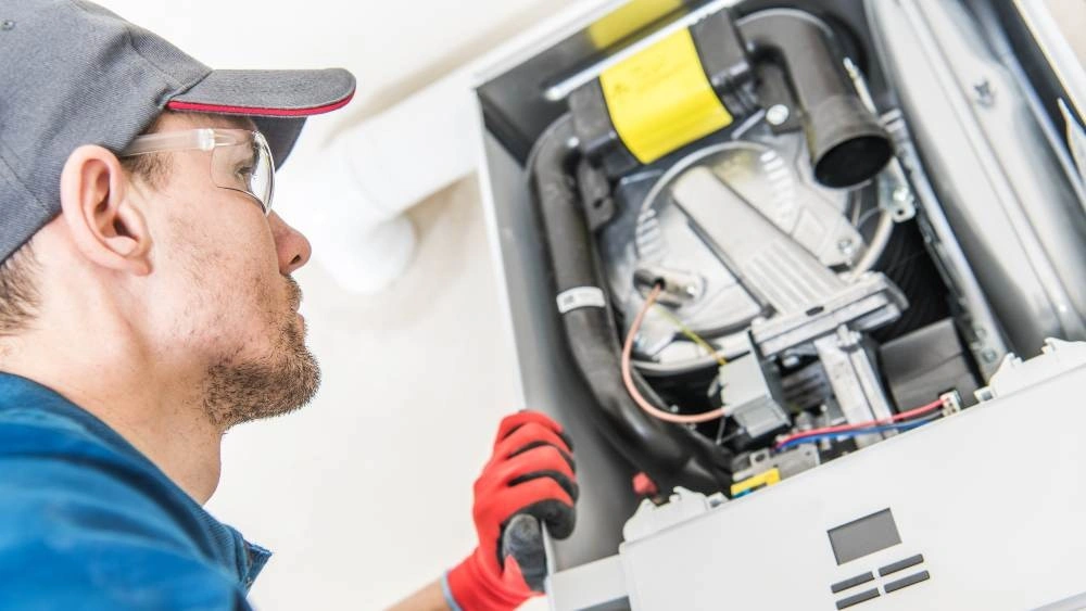 HVAC technician inspecting boiler or furnace.