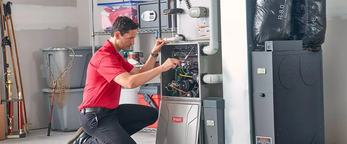 Man performs maintenance on a Bryant furnace.