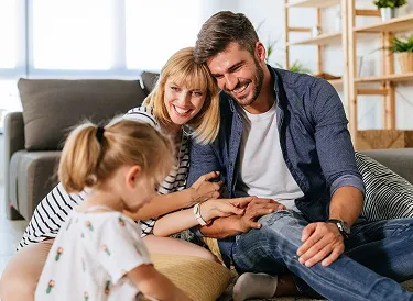 Happy family spending time together on couch, smiling and connecting