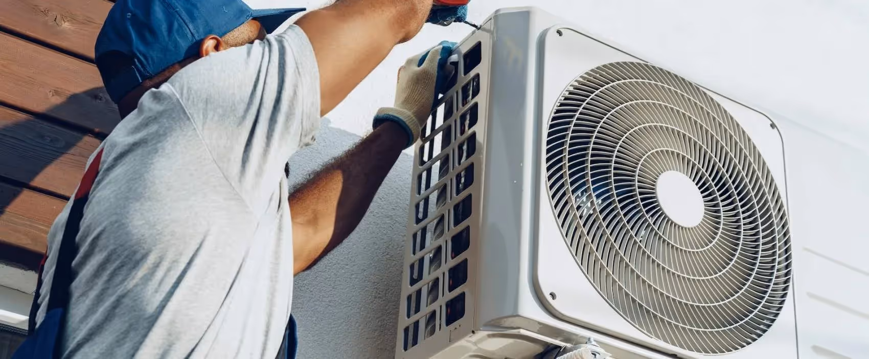 Technician installing or repairing an outdoor air conditioning unit