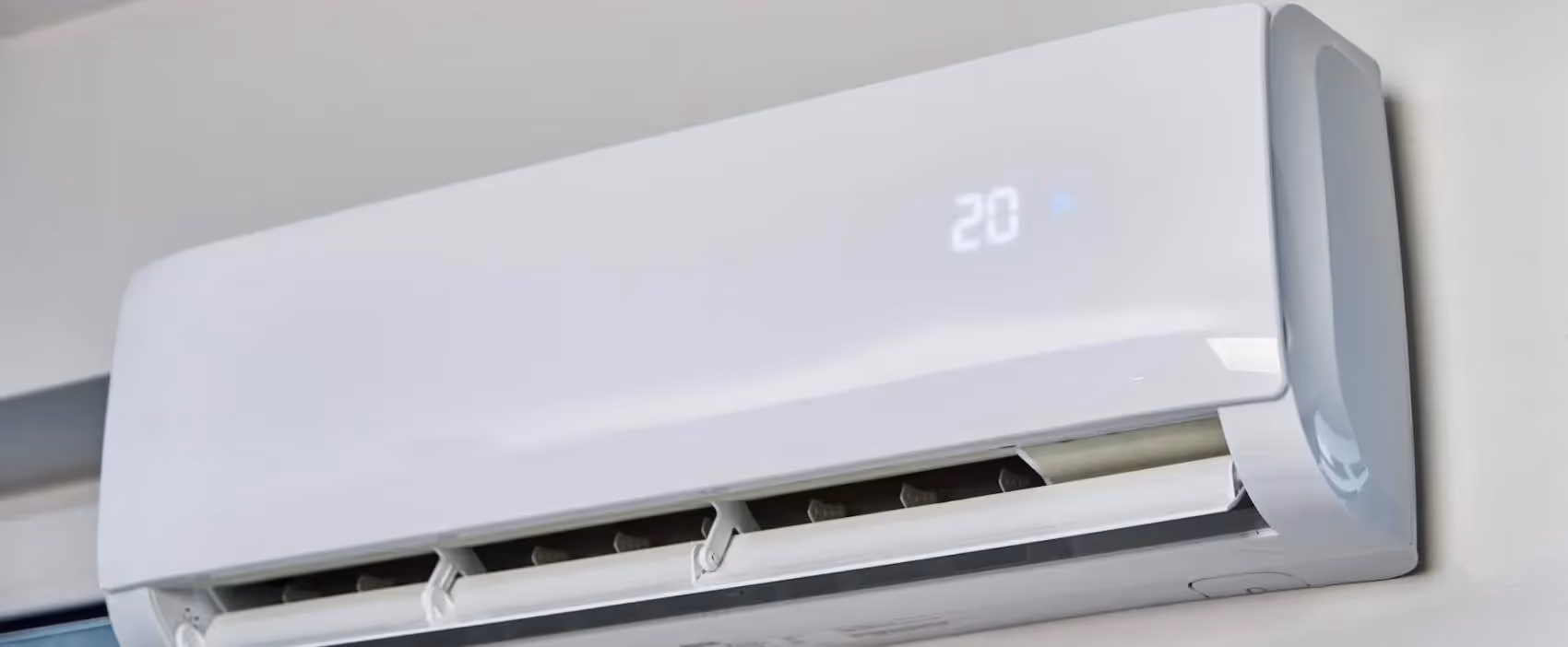 White wall-mounted air conditioner with digital display set to 20 degrees