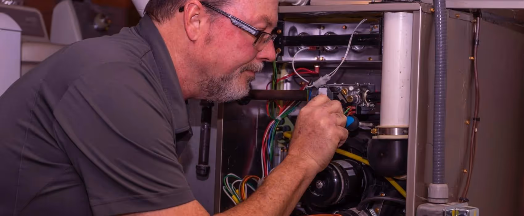 Technician repairing electrical equipment with colorful wires inside panel