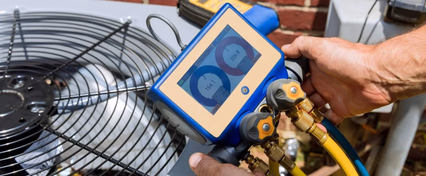 Technician using digital manifold gauge to check HVAC system pressure