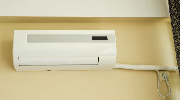 White wall-mounted air conditioning unit with remote control
