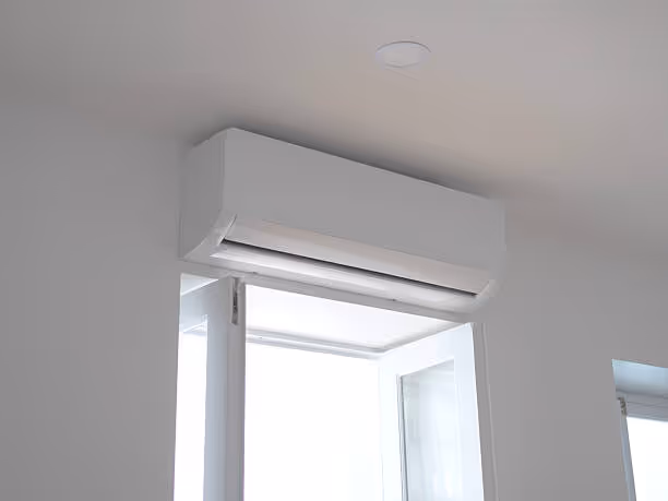 White air conditioning unit mounted above a minimalist white window