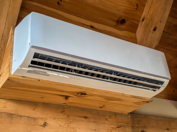 White ductless mini-split air conditioner mounted on wooden wall