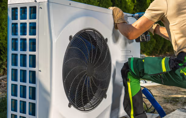 Technician repairing an outdoor heat pump or air conditioning unit