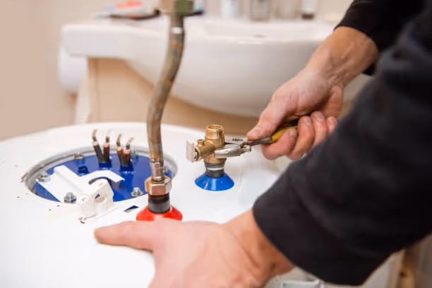Plumber adjusting valves on a water heater with wrench