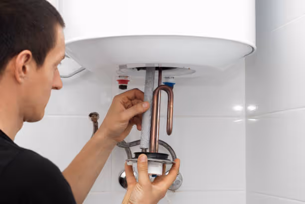 Technician installing or repairing a water heater plumbing connections