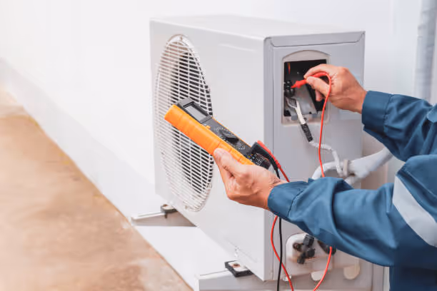 Technician checking electrical connections on an air conditioning unit
