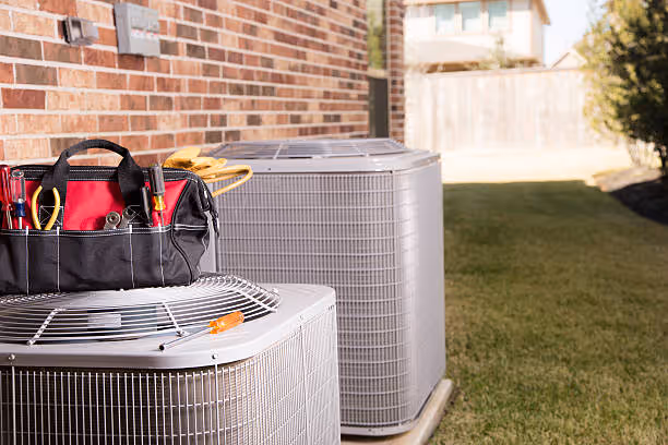 Tool bag on HVAC unit near brick wall and air conditioning systems