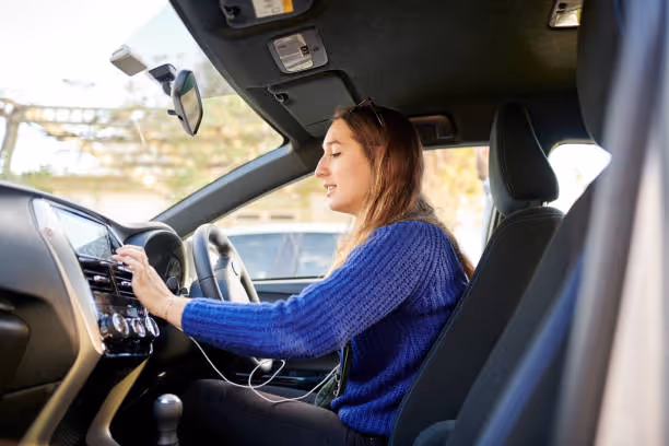 Woman in blue sweater driving car with focused expression