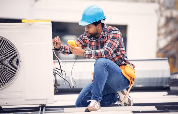 Construction worker in blue helmet checking electrical connections on rooftop