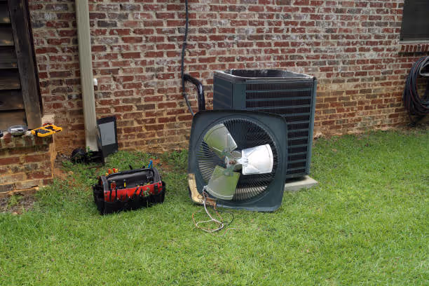 HVAC technician's tools and air conditioning unit on grassy yard