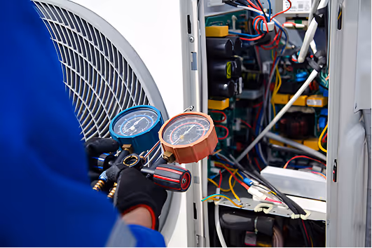 Technician checking pressure gauges while repairing an electrical system