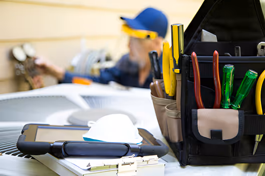 Toolbag with colorful tools and safety equipment on work surface