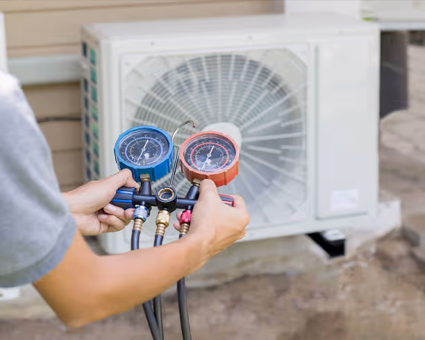 Technician checking air conditioning unit with pressure gauges