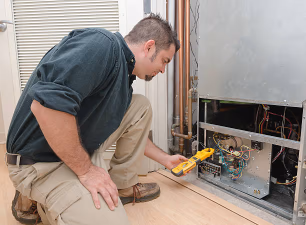 Technician using multimeter to diagnose electrical issue in HVAC system