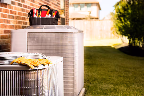 HVAC technician's tools and work gloves on outdoor air conditioning unit