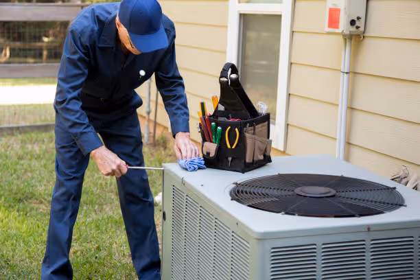 HVAC technician performing maintenance on outdoor air conditioning unit