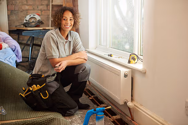 Smiling worker with tools preparing for home renovation near window