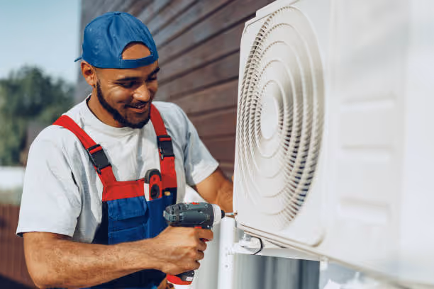 Technician installing or repairing an air conditioning unit outside