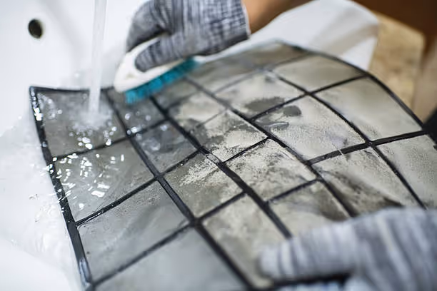 Hands in gloves cleaning and disinfecting tiled surface with spray
