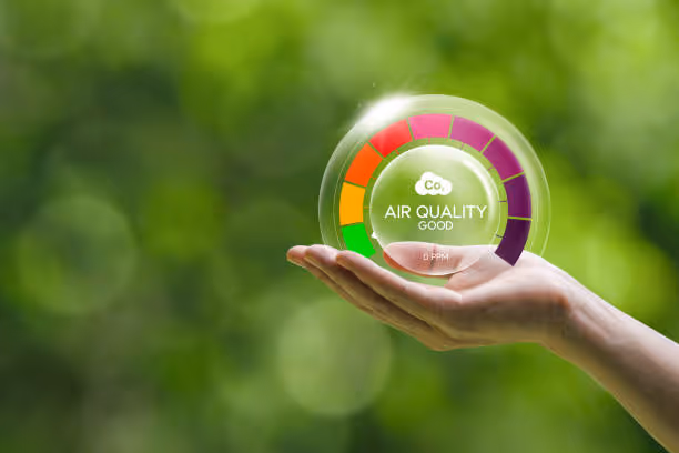 Hand holding air quality meter showing good environmental status