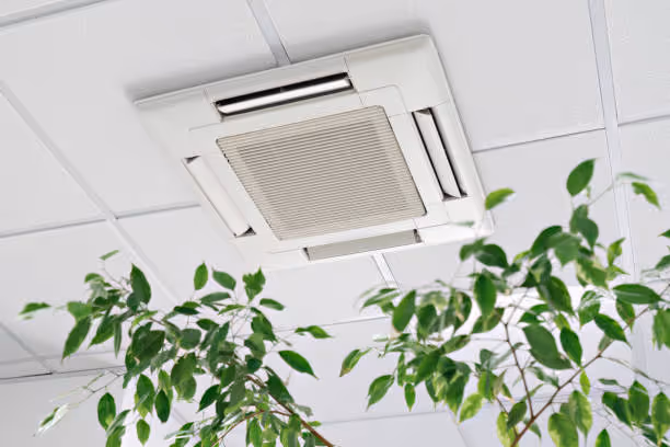 Ceiling-mounted air conditioning unit near green leafy plants