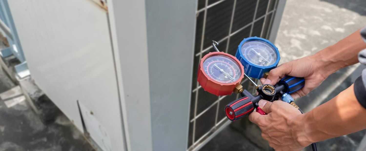 Technician checking pressure with red and blue manifold gauges