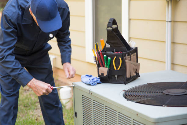 Technician repairing air conditioning unit with tools nearby