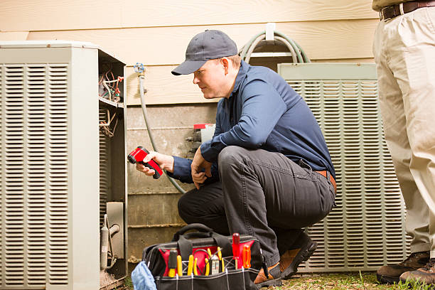 HVAC technician repairing air conditioning unit with tools outside