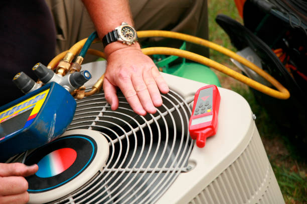 Technician checking HVAC unit with tools and refrigerant gauges