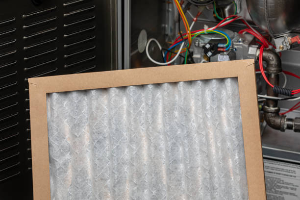 Clean air filter in wooden frame against electrical equipment background